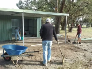 Man with a shovel standing in front of a shed